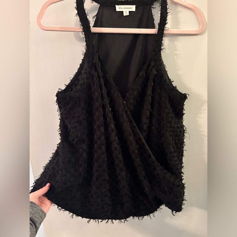 Black sleeveless blouse. Feathered details